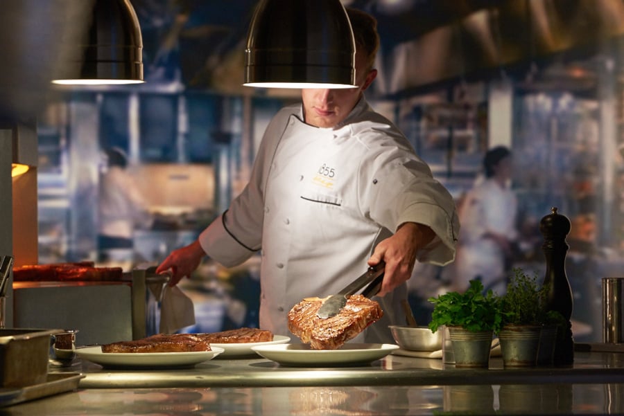 foodservice chef cooking and serving steak